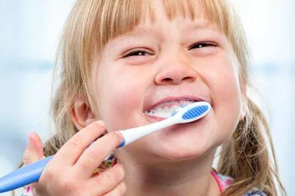 young blond girl brushing her teeth, pediatric dentistry University City, MO dentist