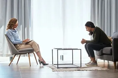 Therapist providing trauma-focused counseling to woman during recovery session