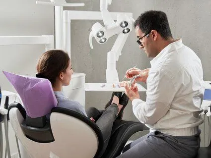 male dentist talking with female patient sitting in exam chair, gentle dentist Cary, NC family dentist