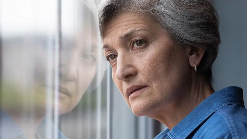 Older woman gazing out a window
