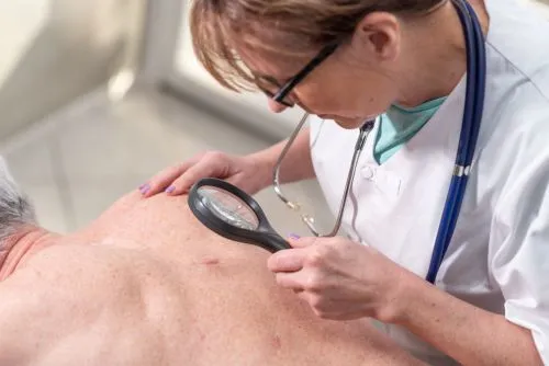 Dermatologist inspecting a patient's skin for disease