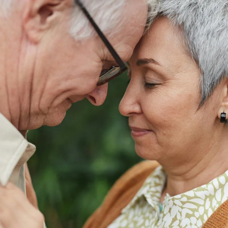 older couple touching foreheads