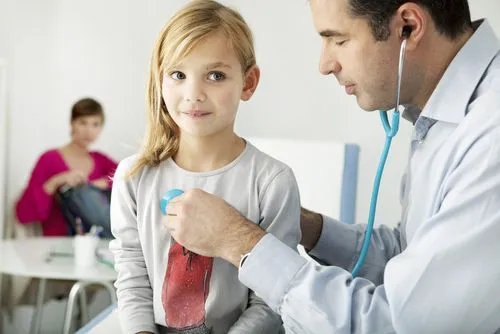 Little girl undergoing a sports physical exam with a pediatrician
