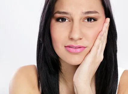 girl holding jaw in pain, needs TMJ treatment Rocky River dentist