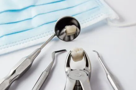 assortment of dental tools and loose crown on white counter, dentist Albuquerque, NM general dentistry