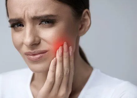 woman holding jaw in pain, needs emergency dentist Phoenix, AZ emergency dental care