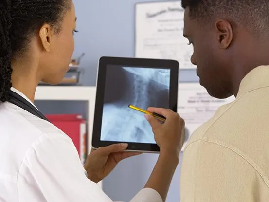 doctor and patient looking at an X-ray of a spine