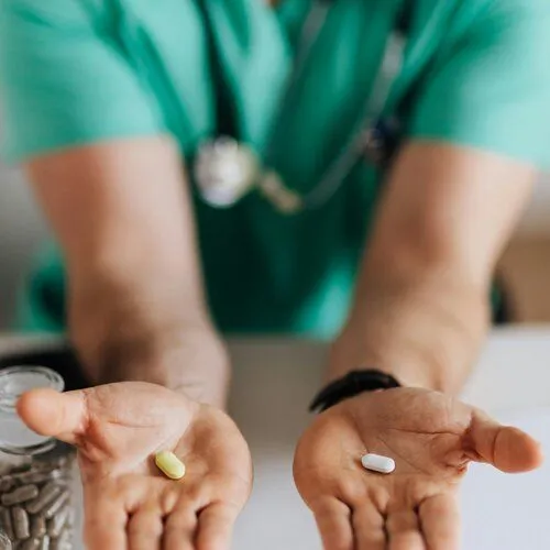 person holding two pills