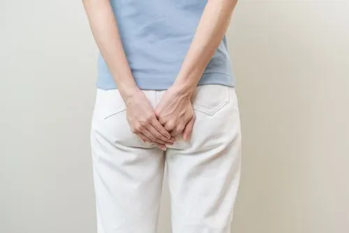 Female patient experiencing discomfort from anal warts