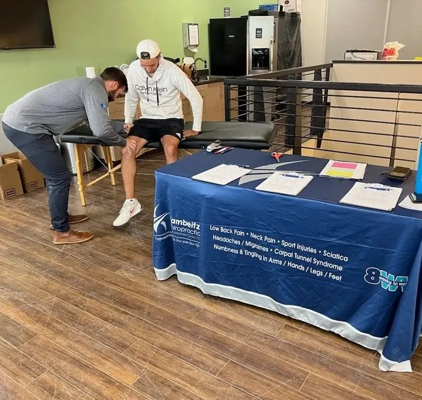Chiropractor helping a participant at an athletic event with massage, stretching, and myofascial therapy