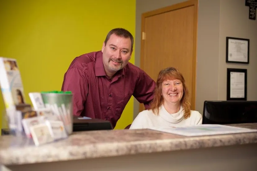 Image of the Dr. and staff at the front desk