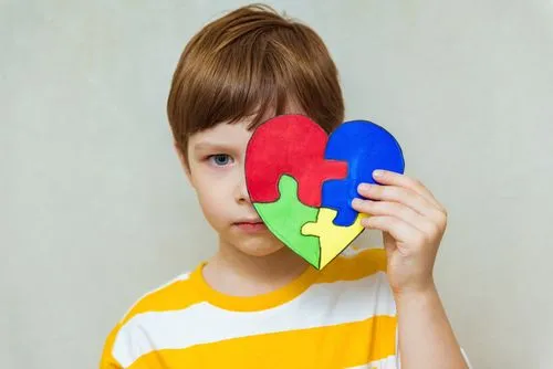 Pediatric autism awareness concept with child and jigsaw heart
