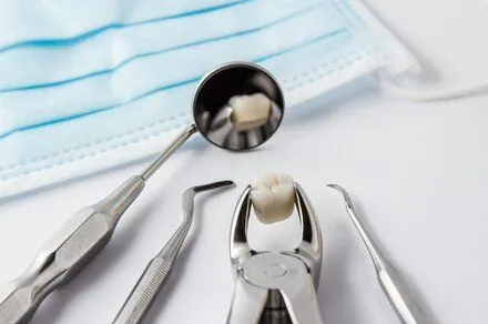 assortment of dental tools on white countertop with extracted tooth, general and cosmetic dentistry Rocky River, OH dentist