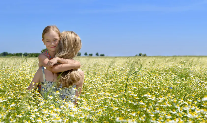 Mother and daughter in field of flowers