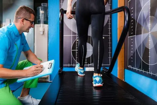 Podiatrist assessing a patient's gait abnormalities during a clinic visit.