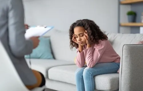Child with depression during behavioral health evaluation with a pediatrician