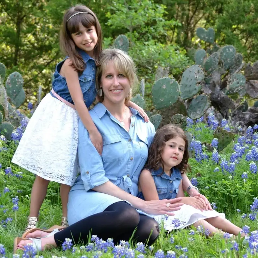 A woman sitting with two girls