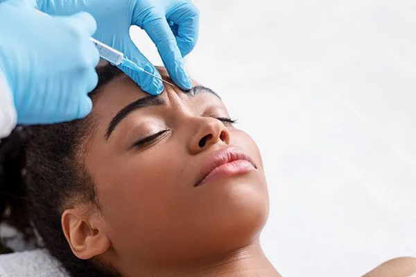 Woman undergoing cosmetic Botox injection to reduce glabellar lines