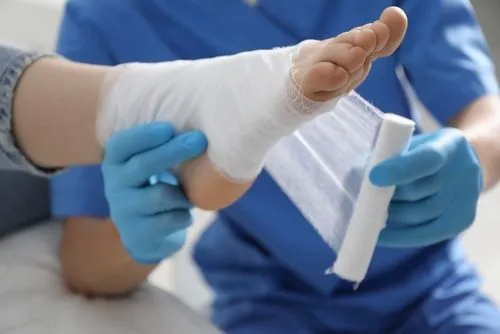 Podiatrist bandaging a patient's foot wound