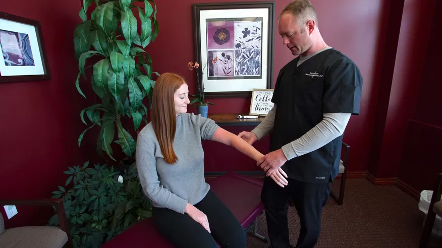 Chiropractor adjusting a patient's left elbow