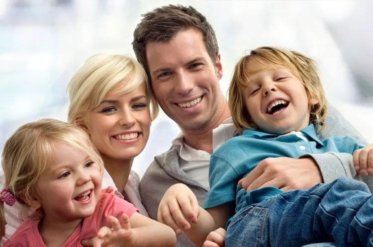 parents holding two young kids, smiling and laughing, general and cosmetic dentist Harrisburg, PA