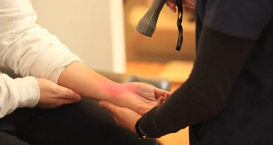 physical therapist in NYC treating wrist pain and carpal tunnel syndrome utilizing the litecure class 4 hot laser | laser therapy for physical rehabilitation