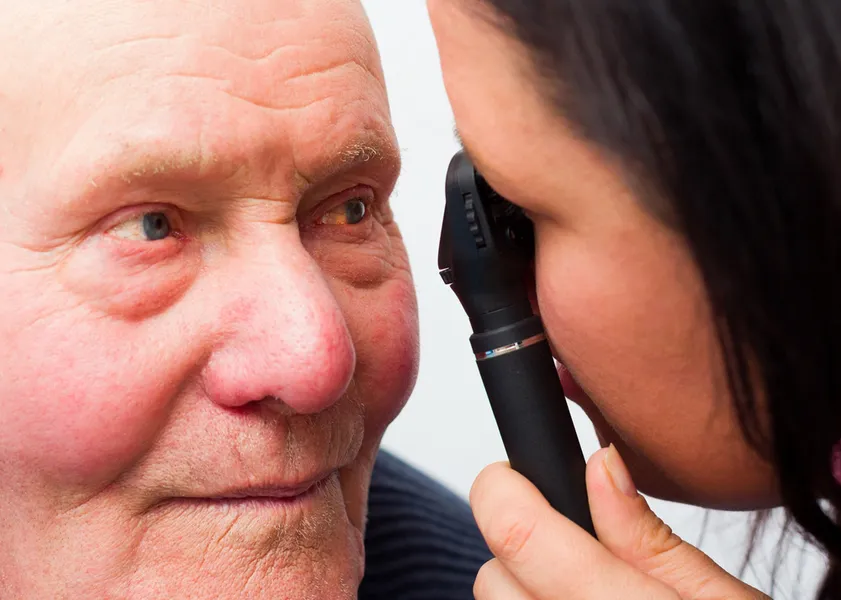 optometrist examining a mans eye