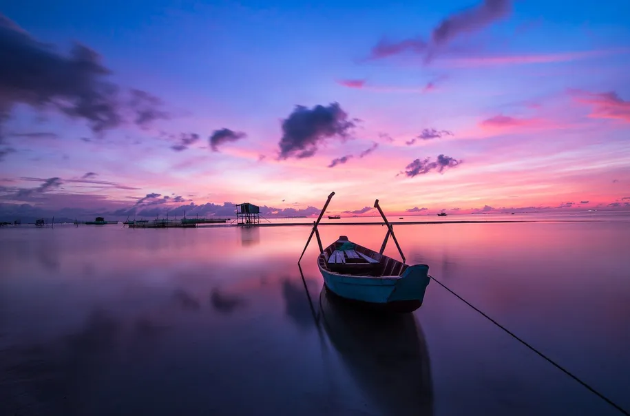 boat on calm lake at sunset