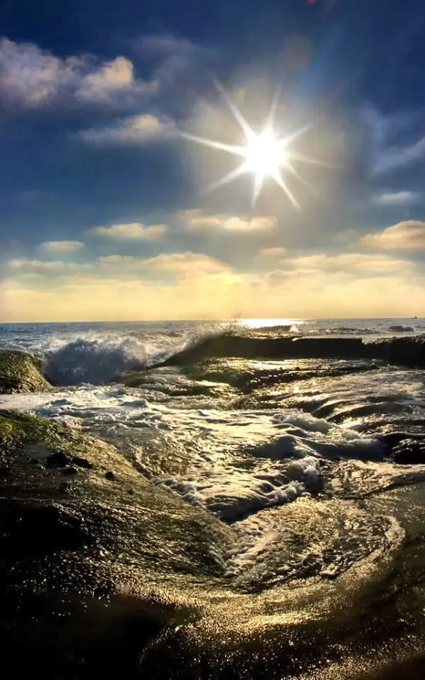 painting of the sun over ocean waves