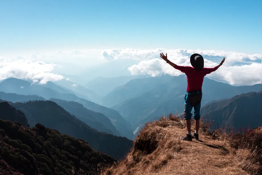 Person Standing On The Edge of a Mountain