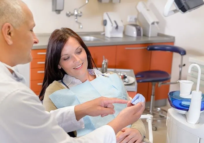 dentist talking to woman in dentist chair Lee's Summit crowns and bridges