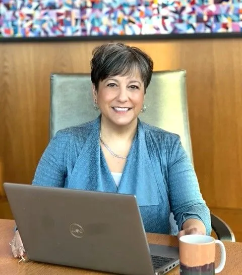 joy allen sitting at a computer, smiling