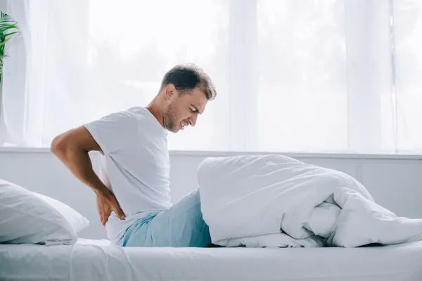 man in bed with back pain