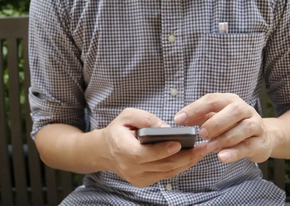 Man with cell phone calls chiropractor after an auto accident