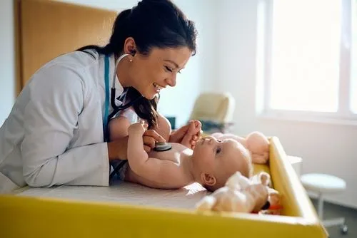 Doctor listening to the heartbeat of a newborn baby with a stethoscope.