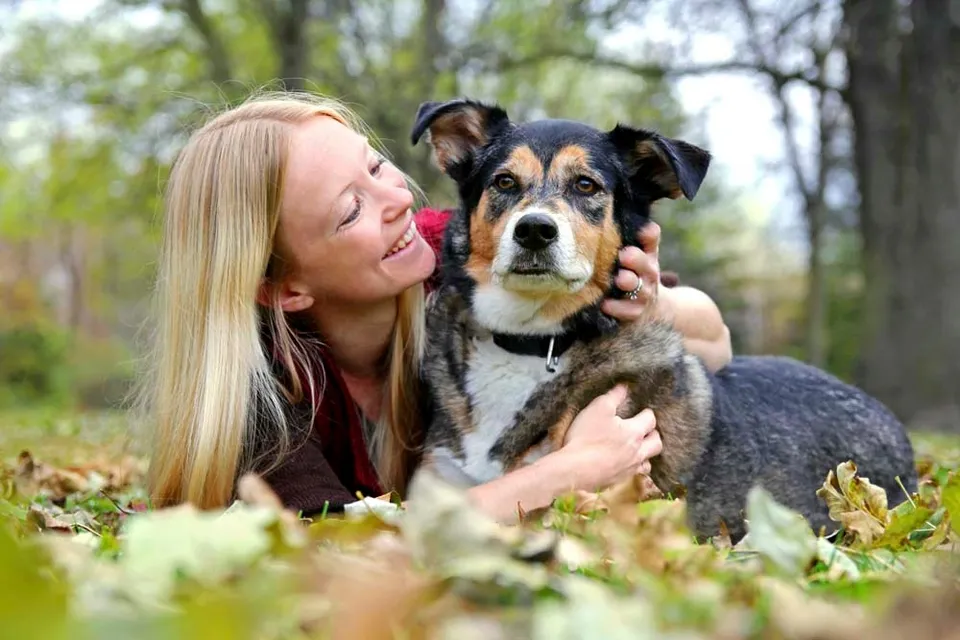 Lady playing with her dog in a park.