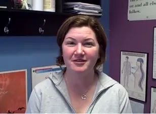 A woman speaking with gray shirt