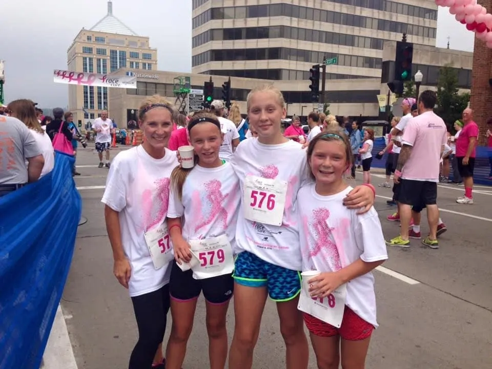 Certified Health Coach Christine Ellis with three girls at a marathon
