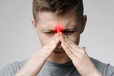 Man holding his sinus in pain with 3d graphics in red