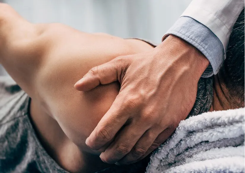 adjusting a shoulder on an athlete