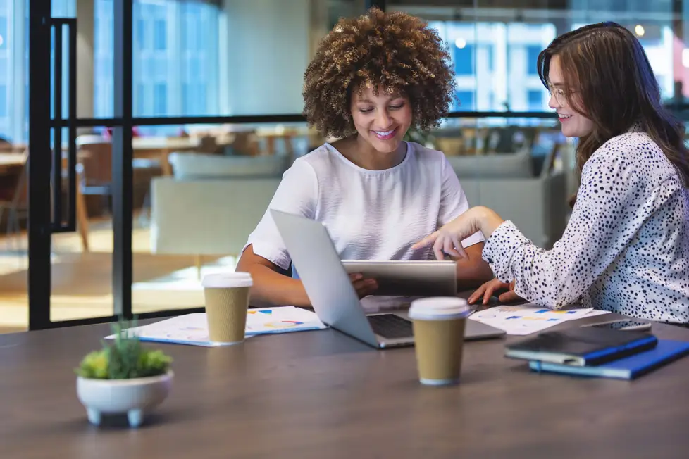 two women sitting looking at laptop