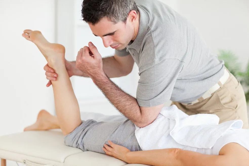 A chiropractor doing leg treatment