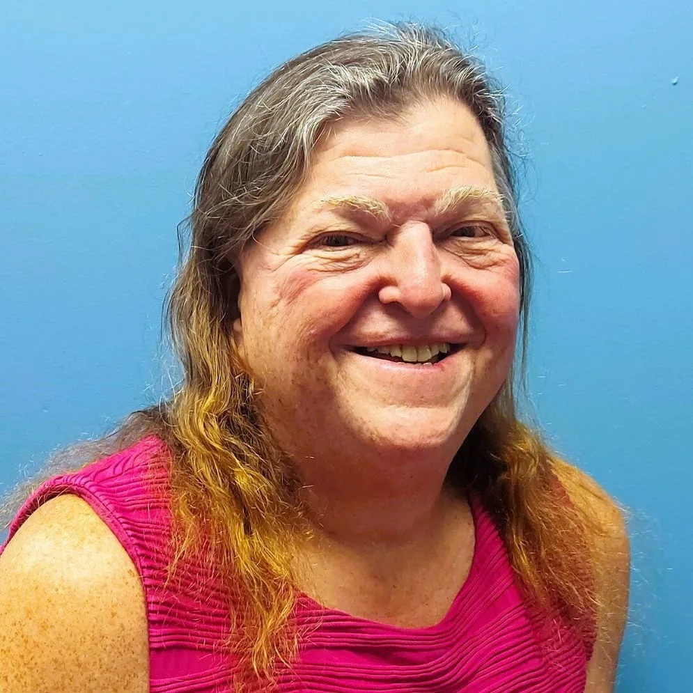Jennifer Marvin smiling in front of blue background