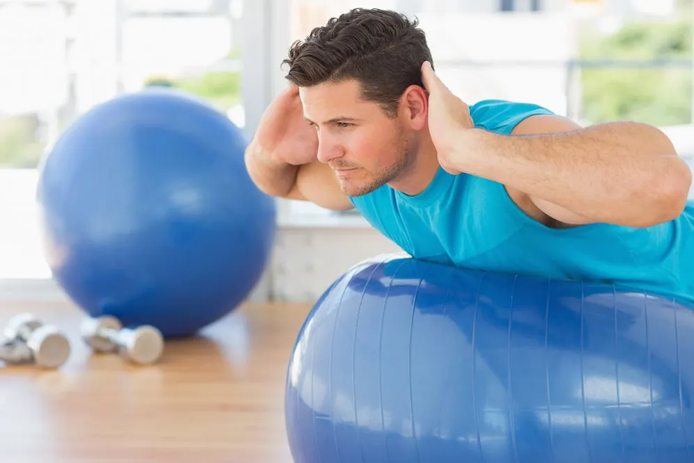 man stretching on a yoga ball